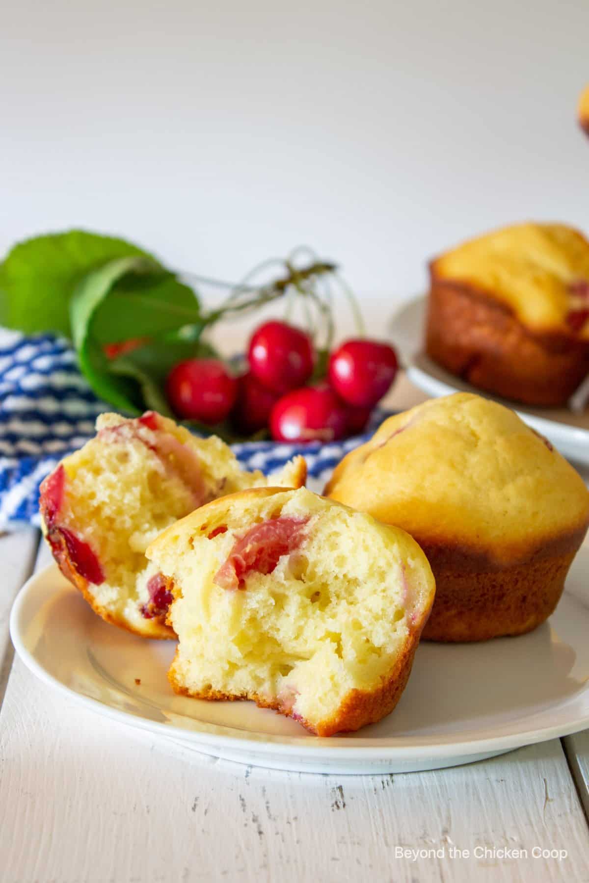 Muffins with cherries on a plate.
