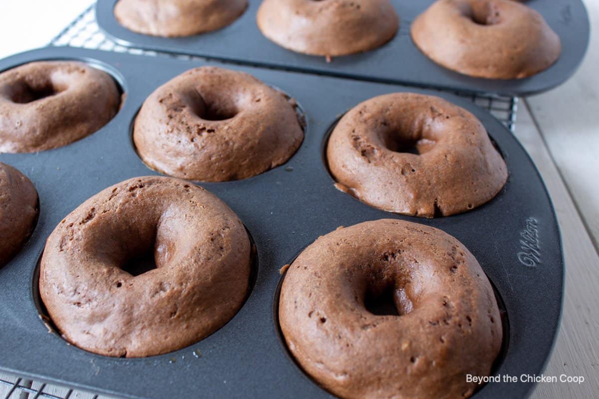 Cooked donuts in a donut pan.