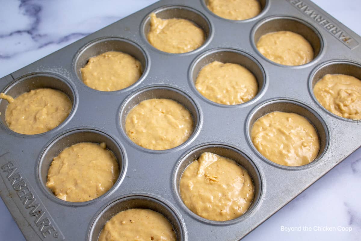 Muffin batter in muffin tins.
