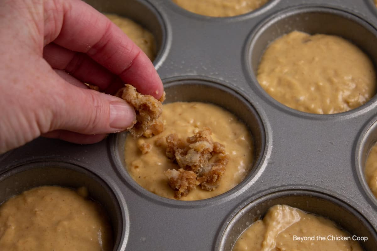 Adding a crumble topping to muffins.