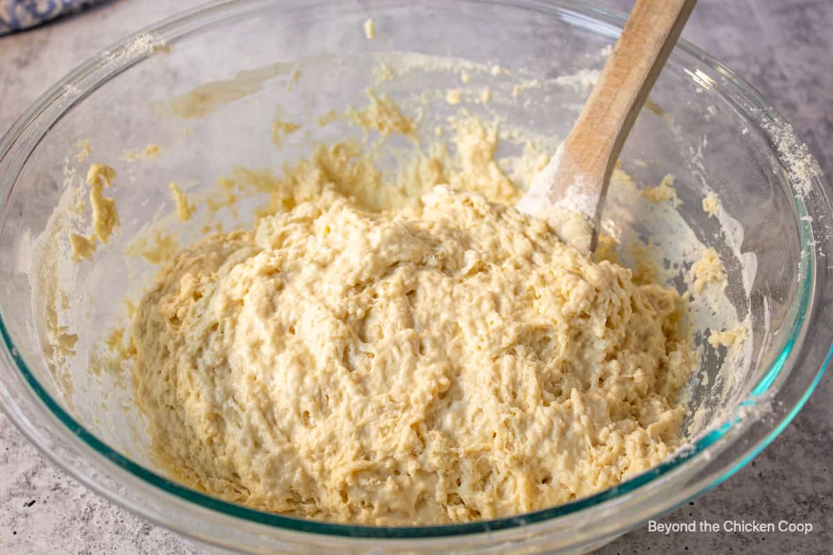 A wet bread dough with a wooden spoon.