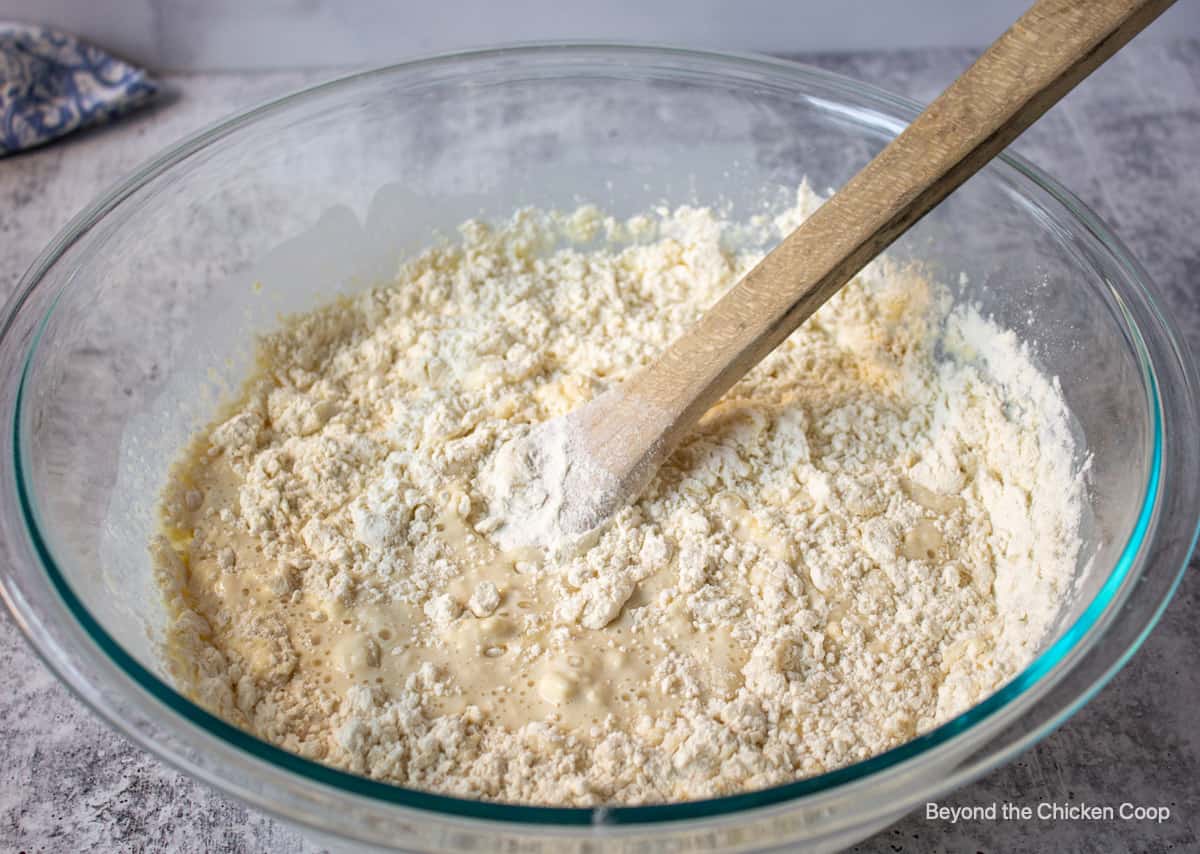 Mixing flour into milk in a large bowl.