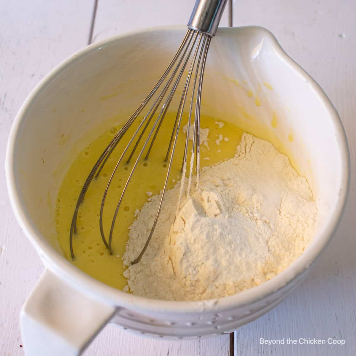 Adding flour to wet ingredients. 