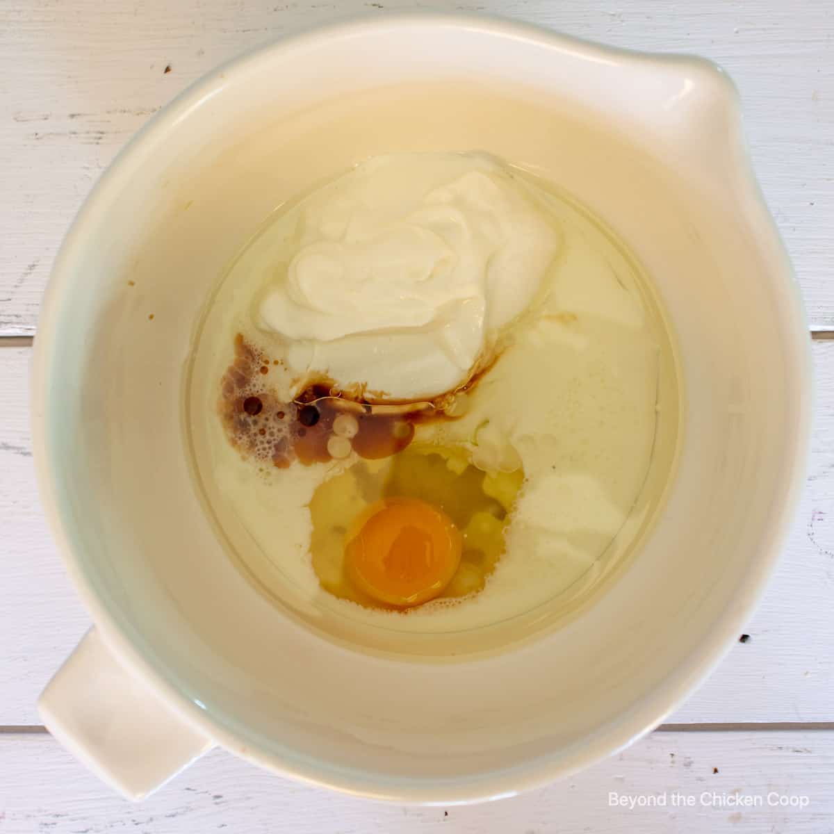 Wet ingredients along with yogurt in a mixing bowl.