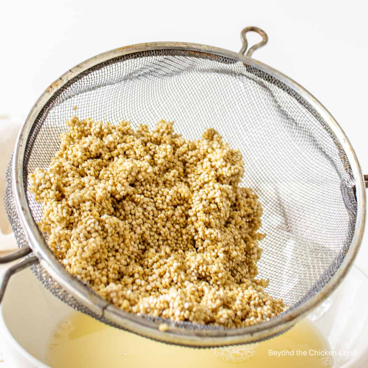 Rinsing quinoa in a sieve.