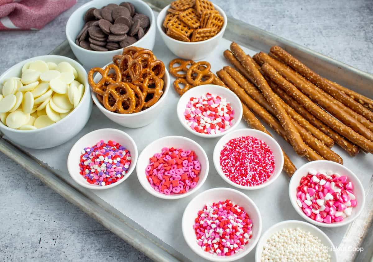 Pretzels and brightly colored sprinkles on a baking sheet. 