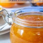 Brightly colored jam in a glass jar.