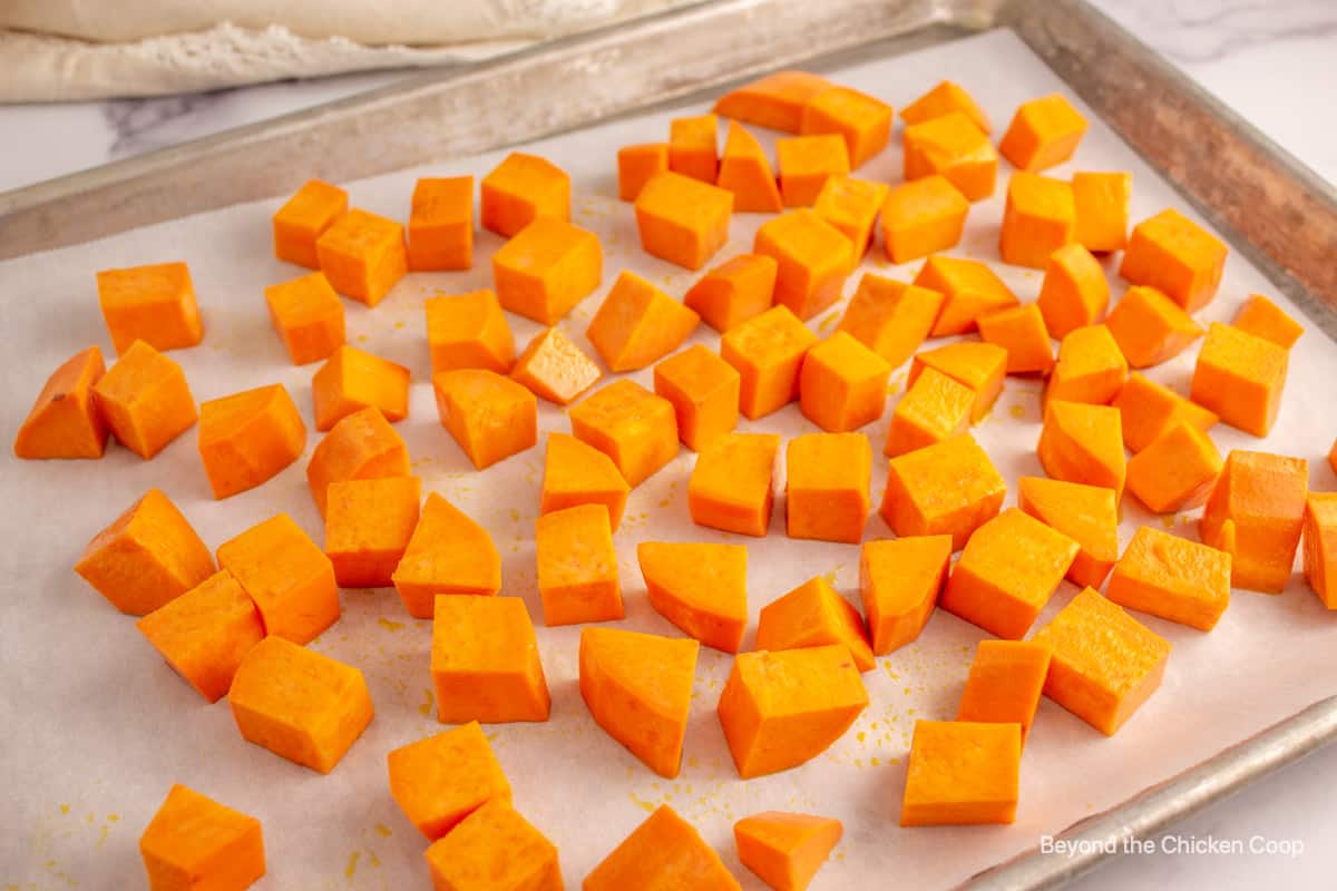 Cubed sweet potatoes on a baking sheet.