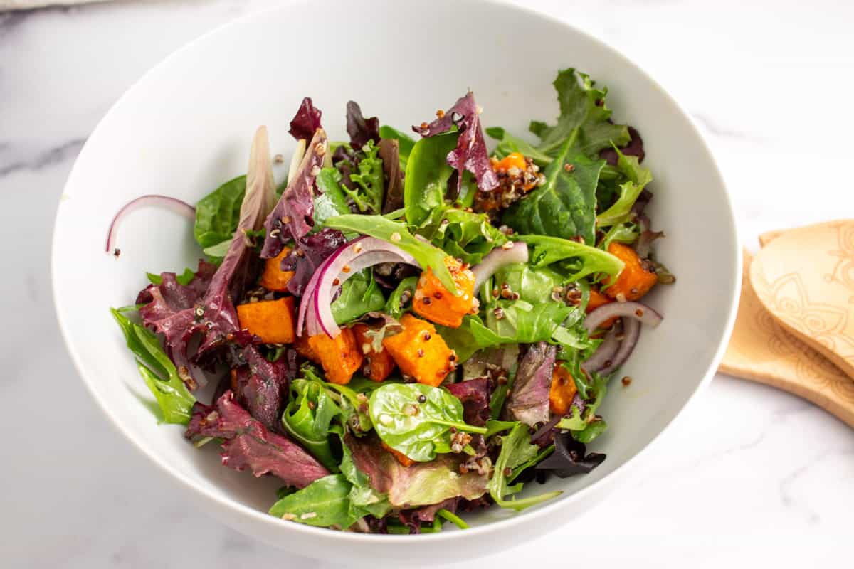 A green salad with quinoa and sweet potatoes.