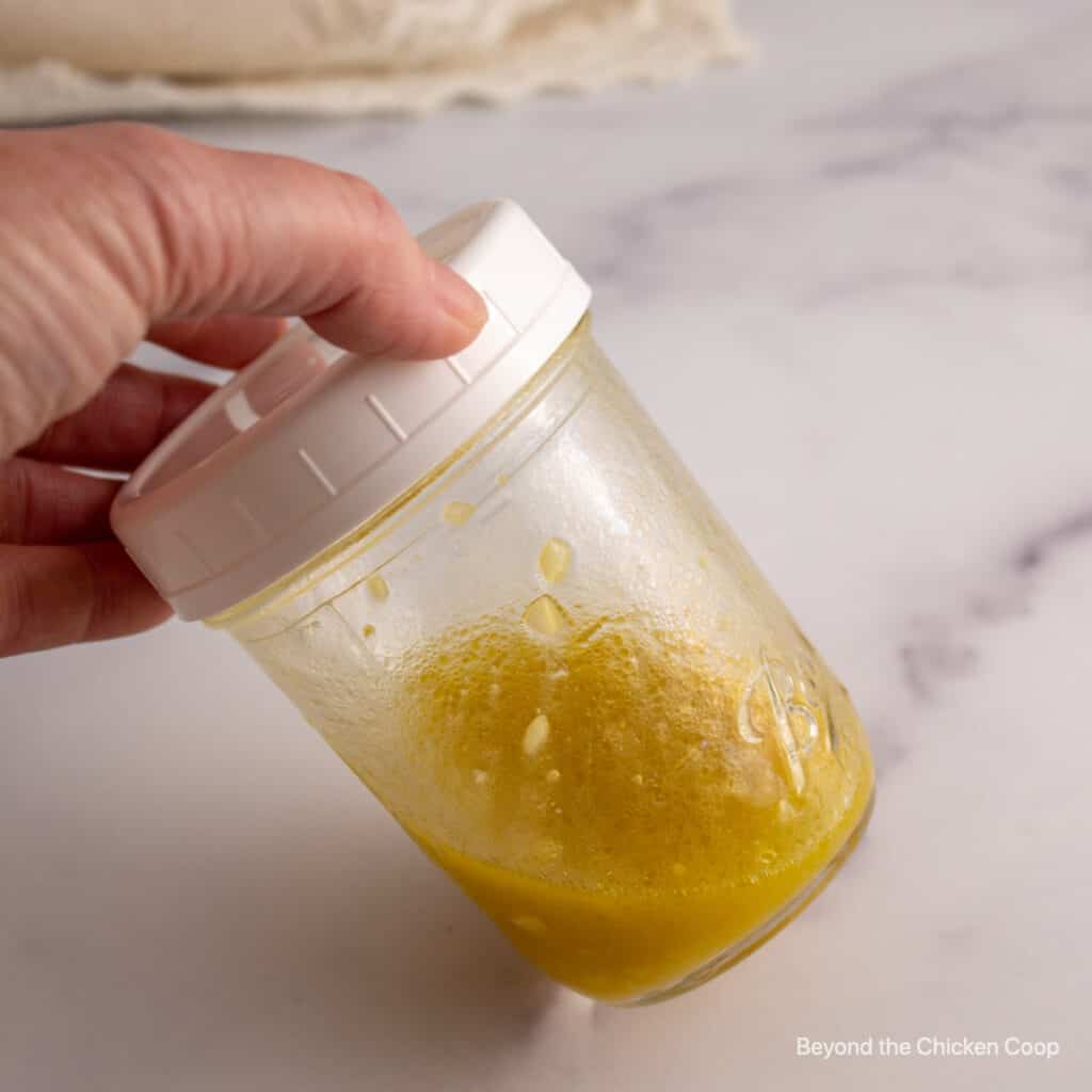 A mixed vinaigrette in a glass jar.