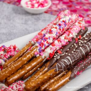 Pretzel rods covered with chocolate and sprinkles.