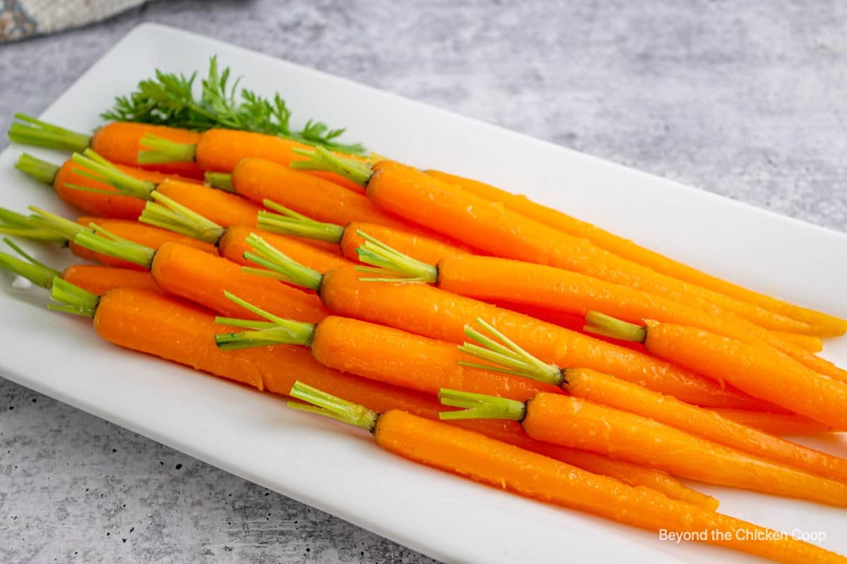Honey glazed carrots on a white platter. 