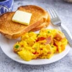 Scrambled eggs with ham and red bell peppers.