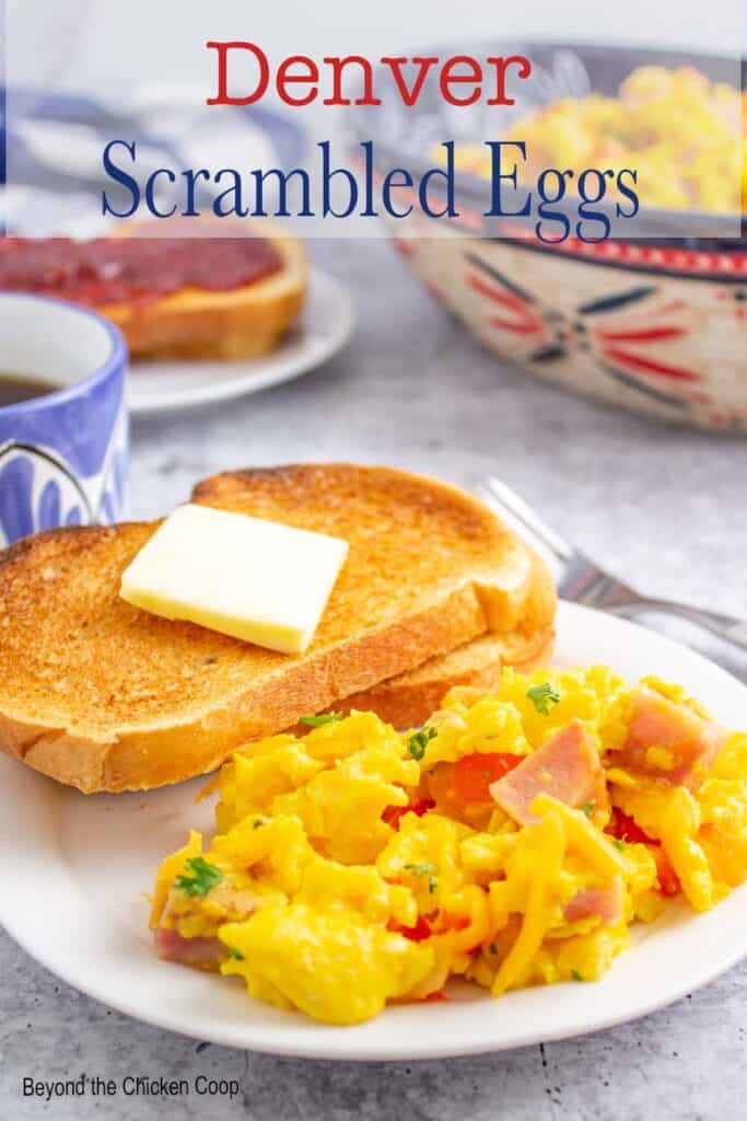 Scrambled eggs on a plate with a piece of toast.