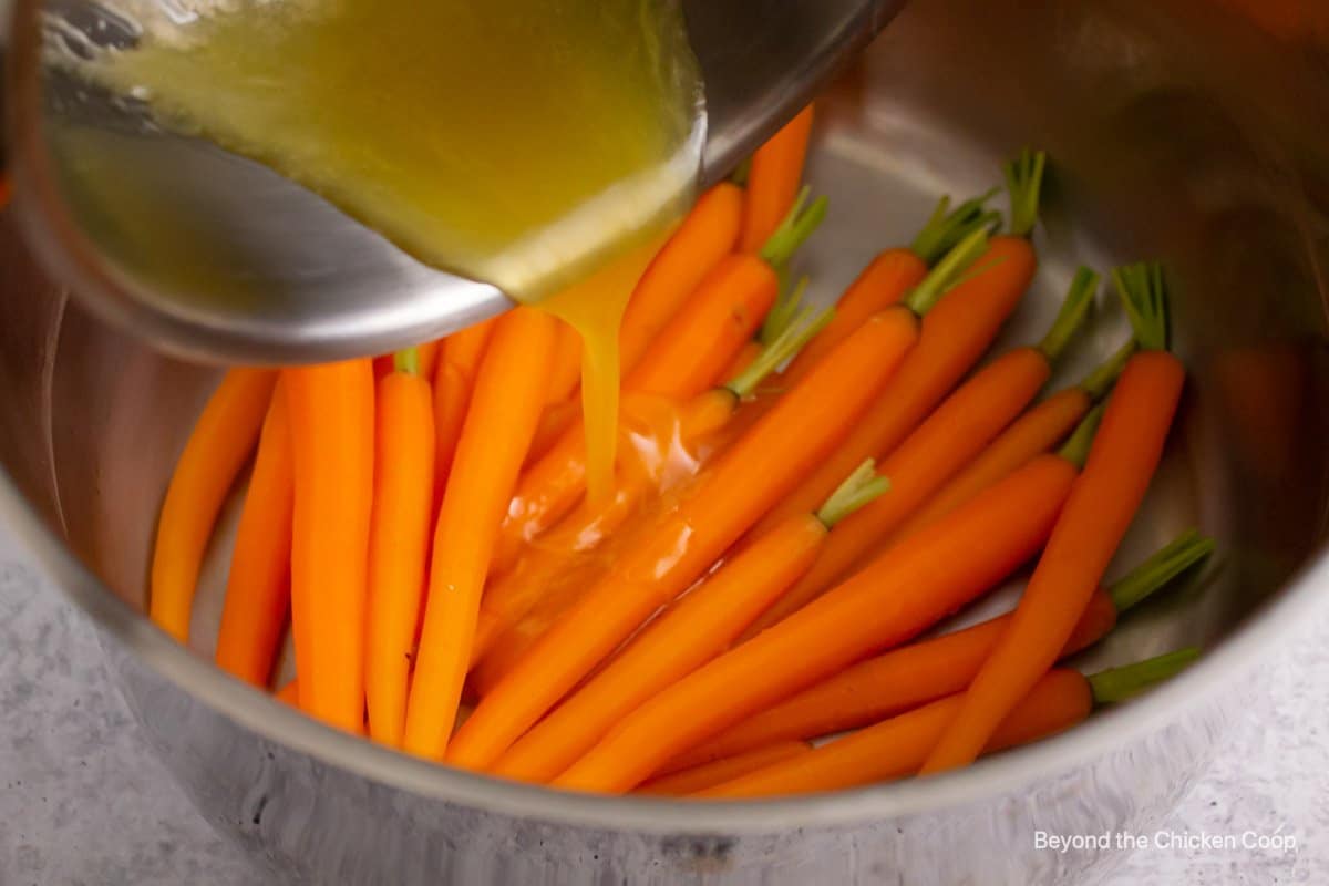 Pouring the butter over the carrots.