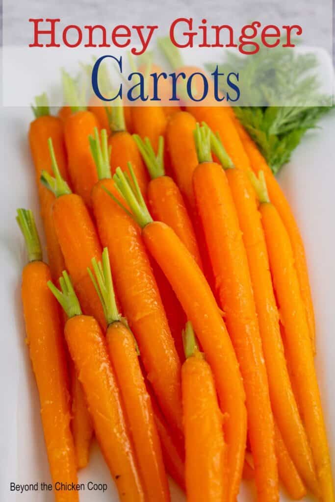 Small baby carrots on a white platter.