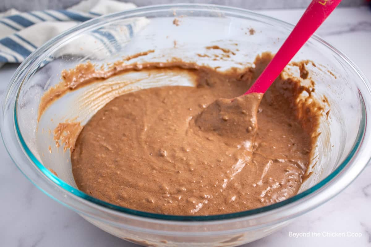 Chocolate cake batter in a glass bowl.