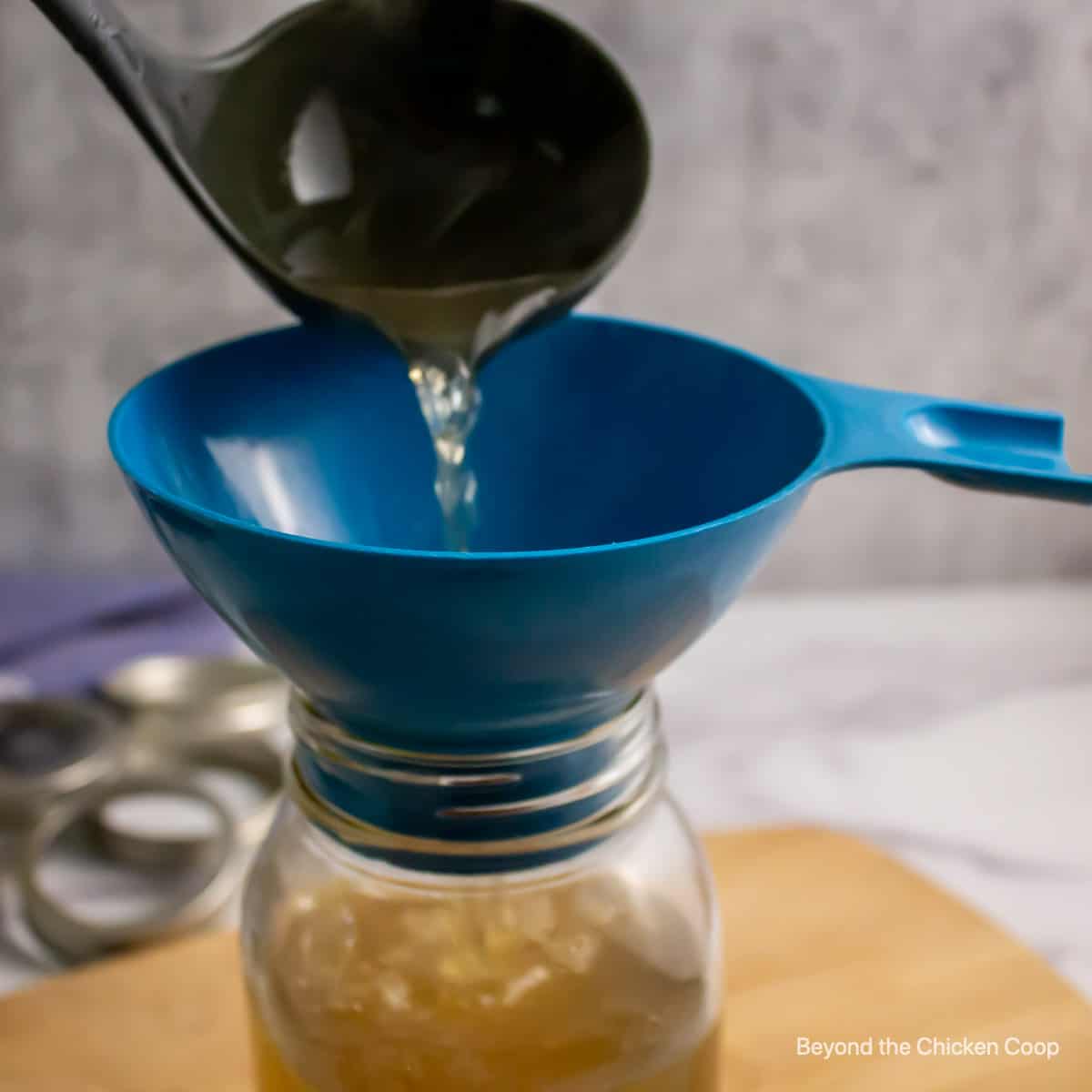 Pouring broth into canning jars. 