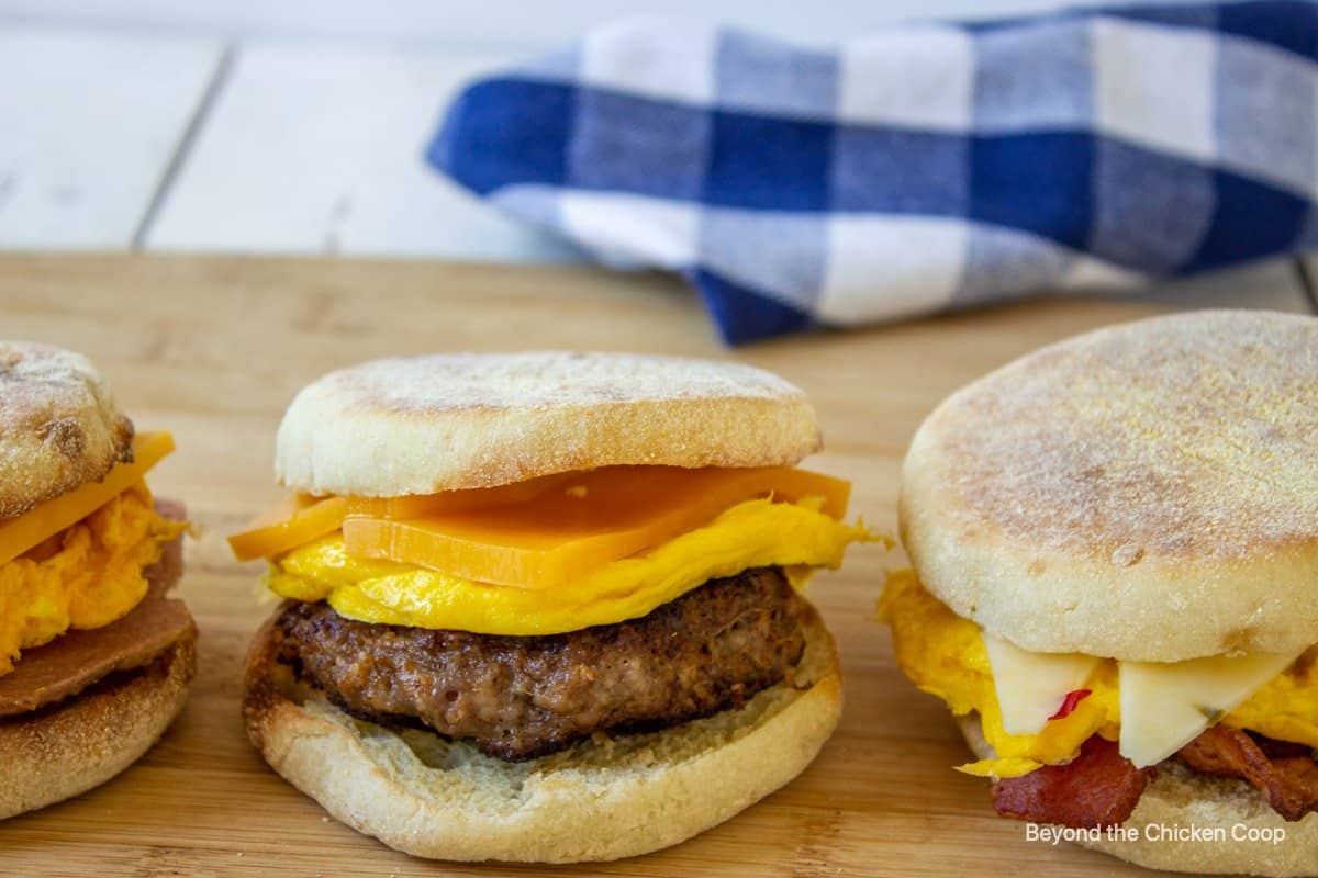 A muffin sandwich with sausage, eggs and cheddar cheese.