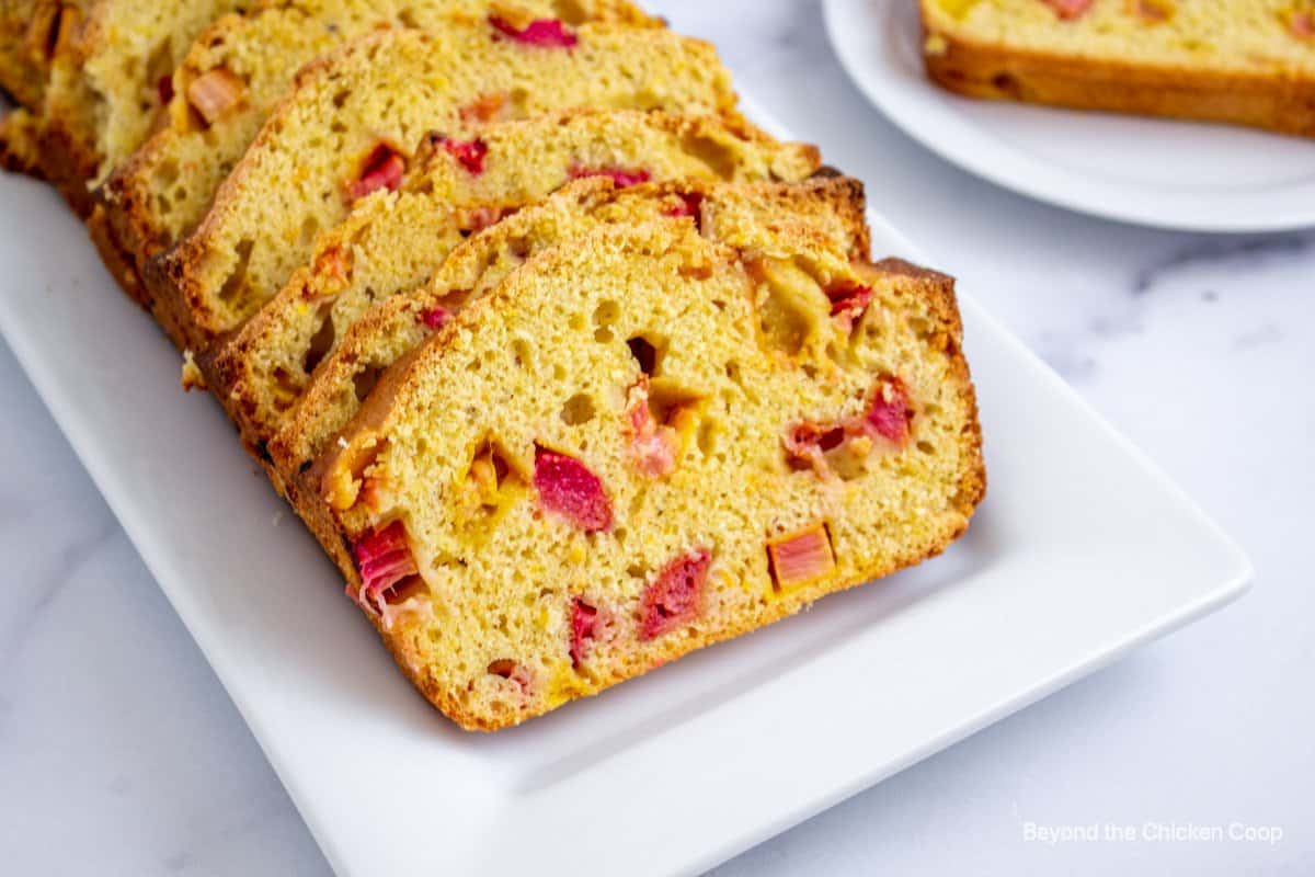 Slices of rhubarb bread on a white platter. 