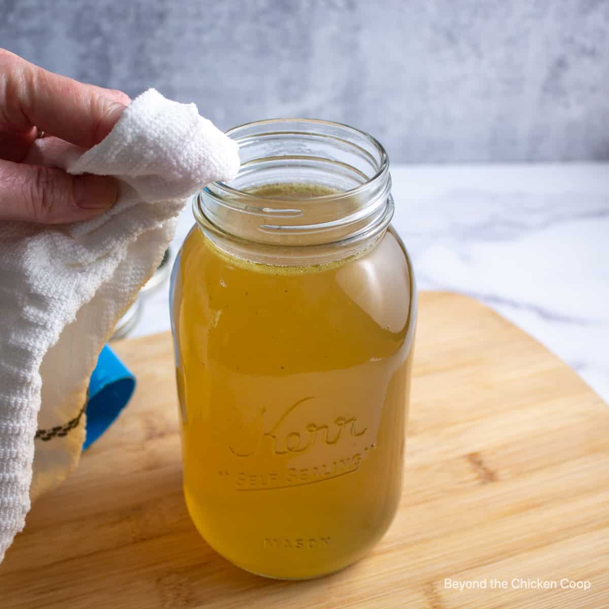 Wiping the rims of a canning jar. 