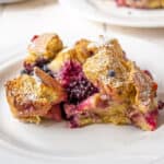 Baked french toast with blackberries and powdered sugar.