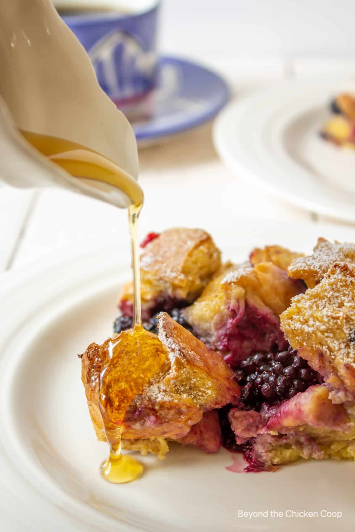 Syrup being poured over a blackberry casserole.