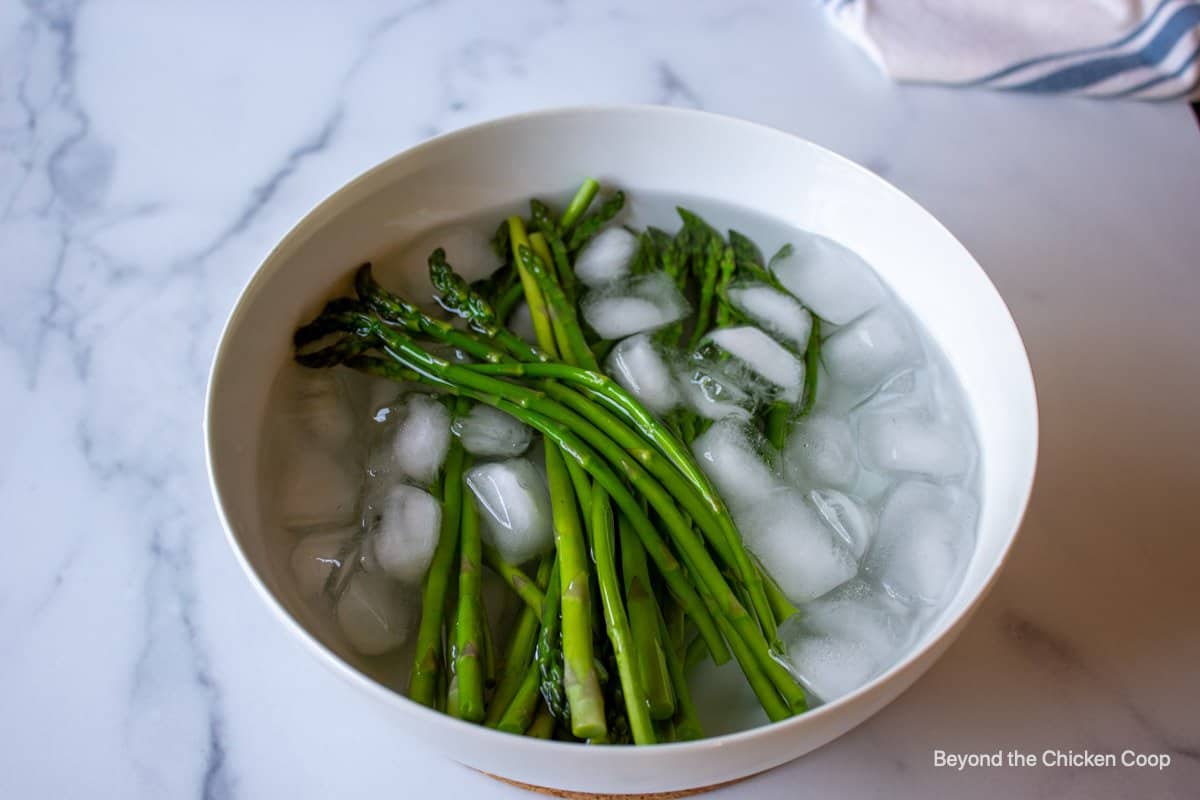 Asparagus in a bowl of ice water.