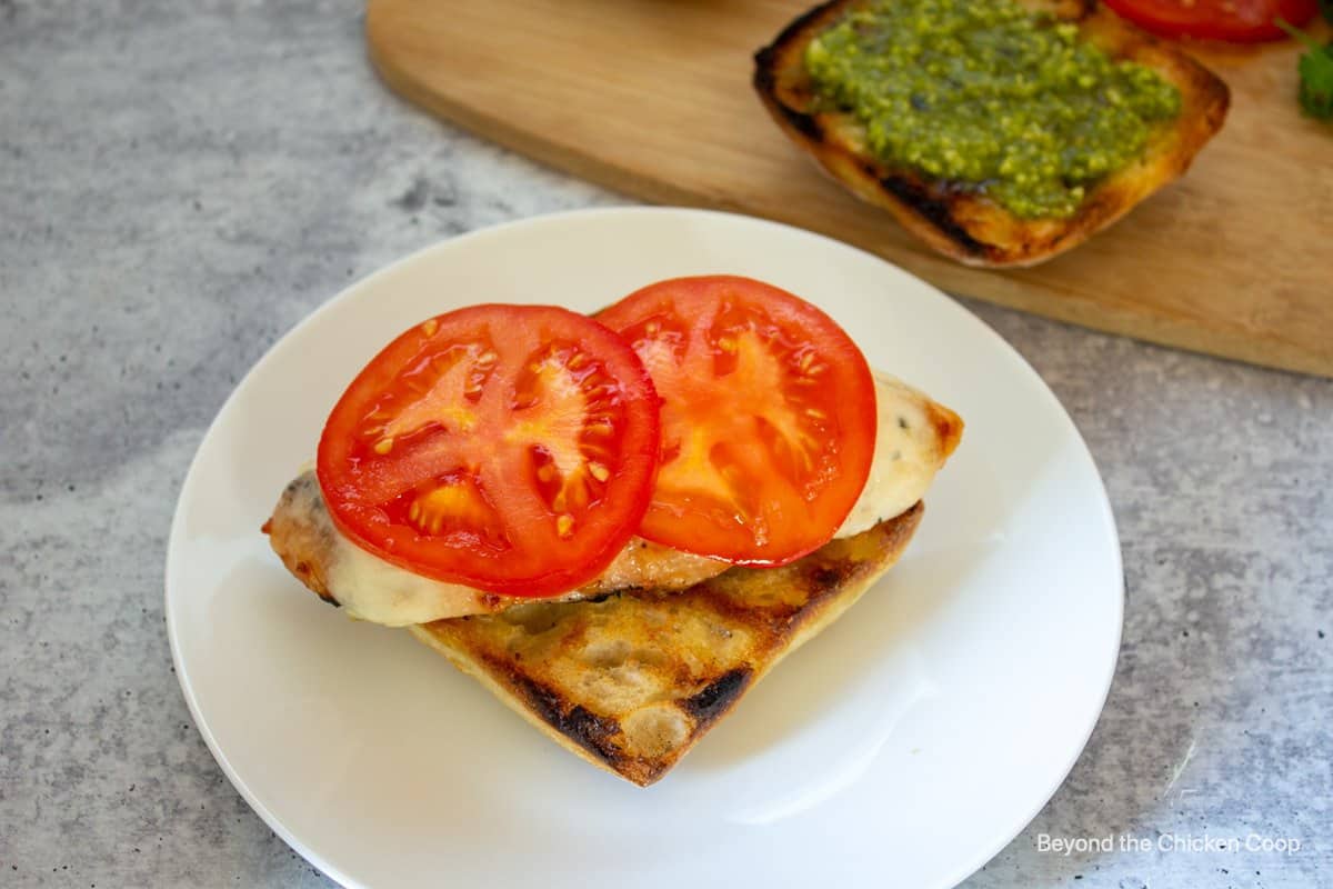 Sliced tomatoes on a chicken sandwich.