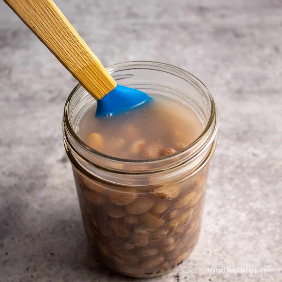 Removing bubbles from a jar of beans.