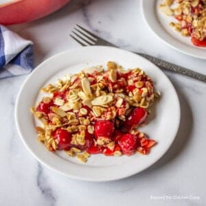 Cherry crisp with sliced almonds on a plate.