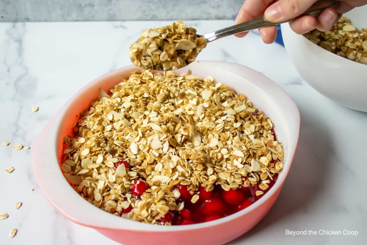 Adding a crumble topping to a dish.