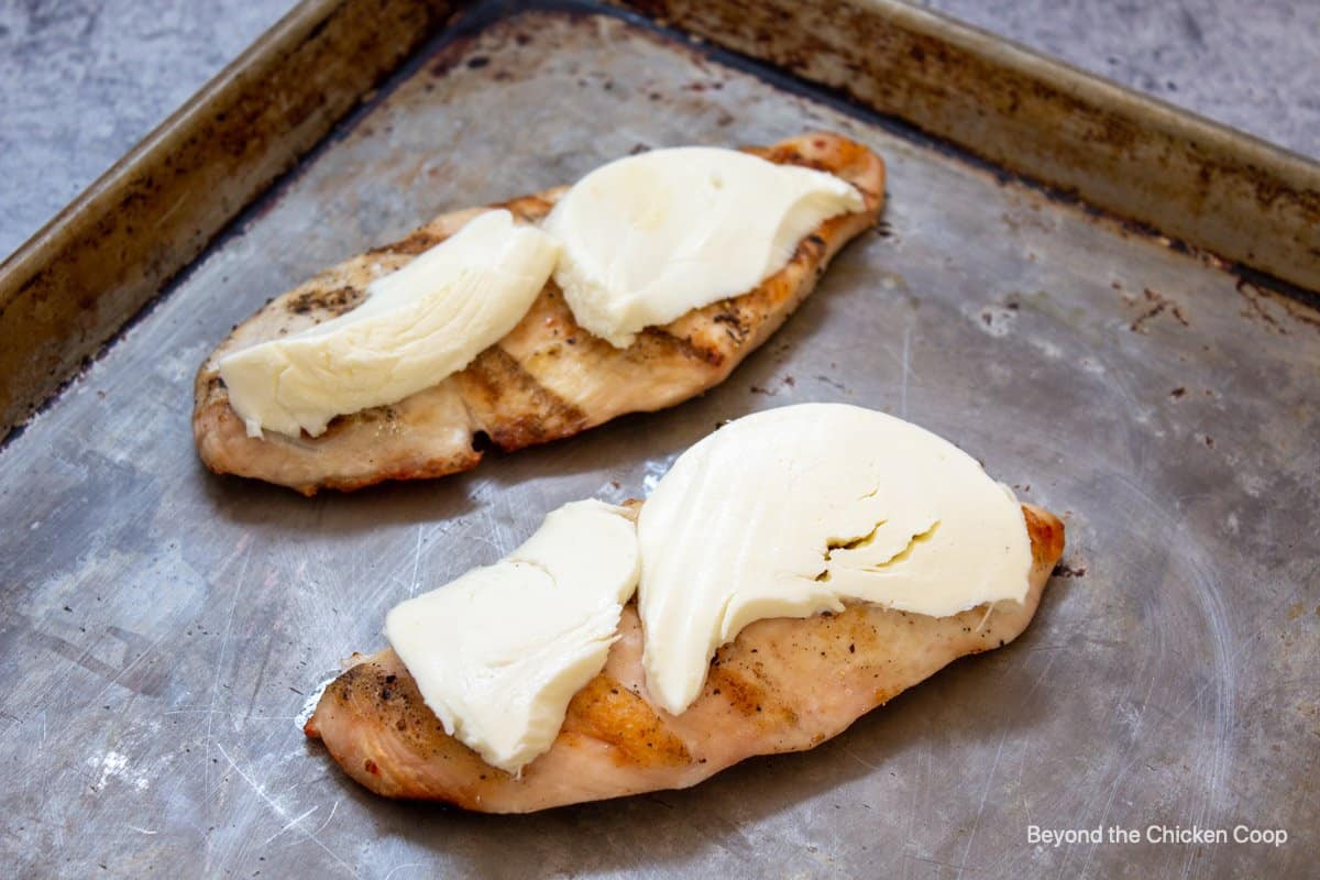 Slices of mozzarella cheese on a chicken breast.