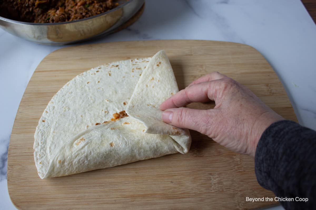Folding sides of tortilla.