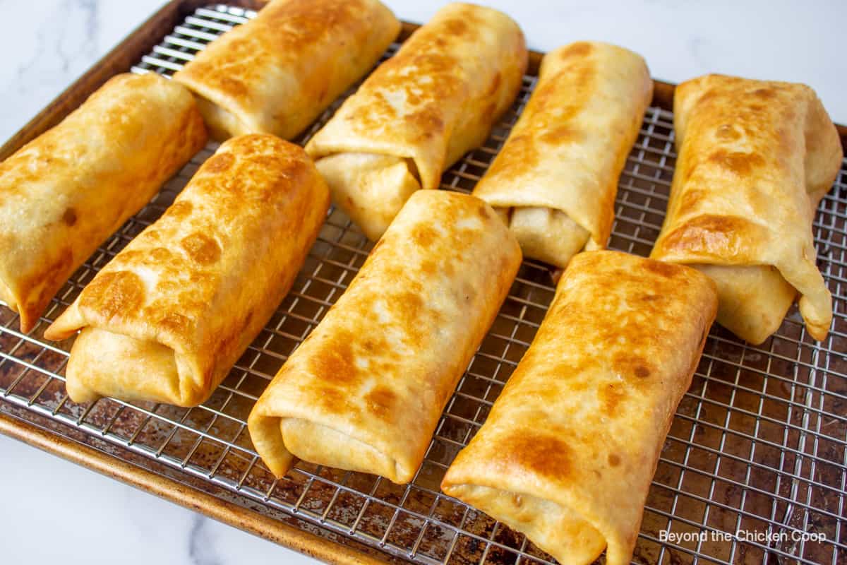 Crispy fried burritos on a baking rack.