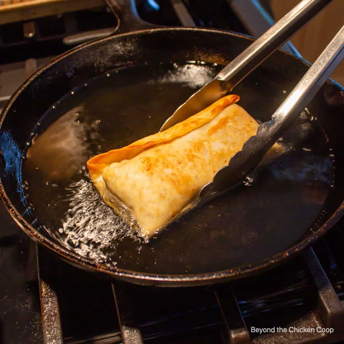 Frying a chimichanga in a cast iron skillet.
