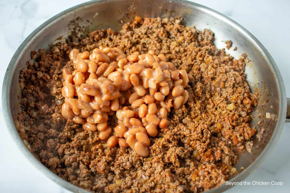 Pinto beans added to ground beef.