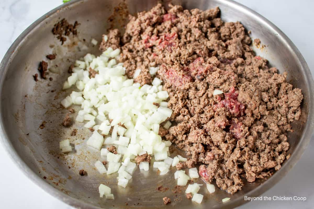 Browned ground beef with onions in a pan.