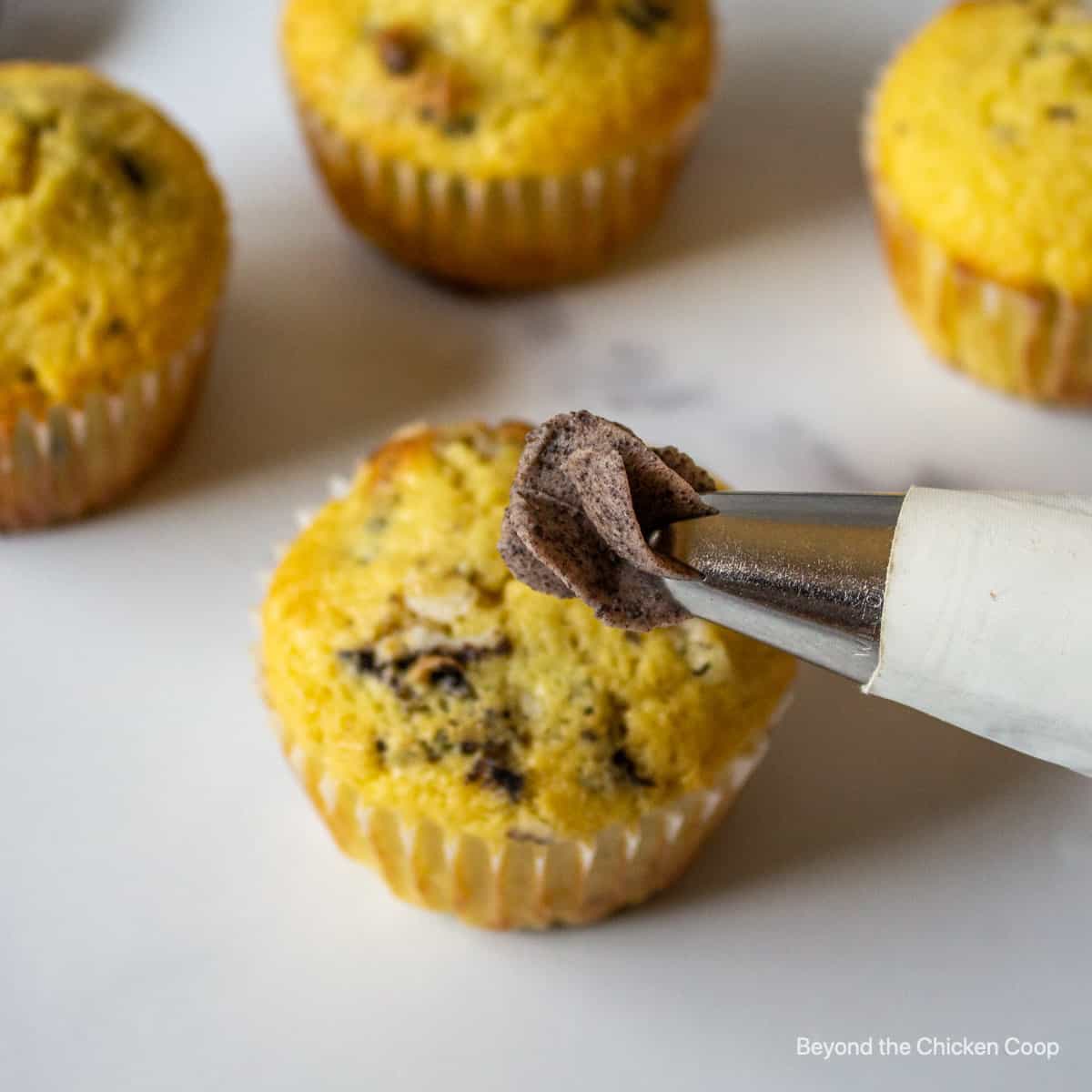 A piping bag with chocolate frosting oozing out of the tip.