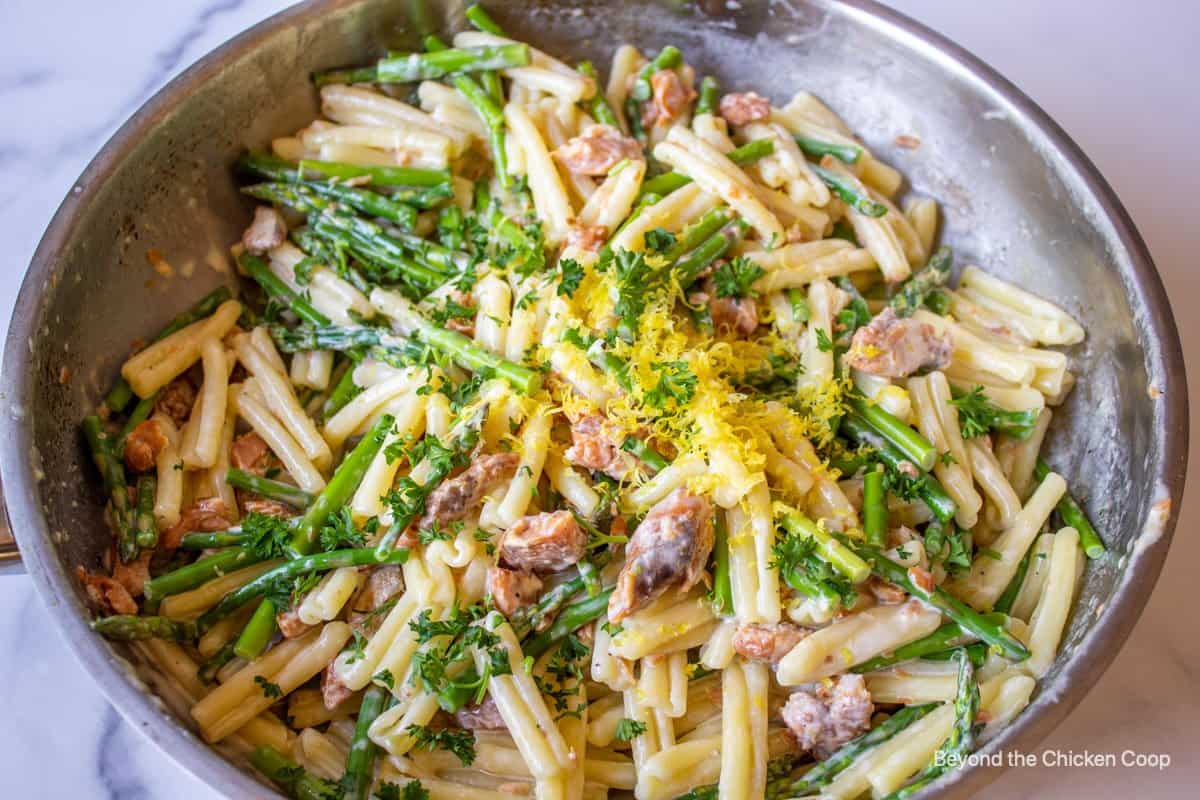 Salmon, asparagus and pasta in a saute pan.