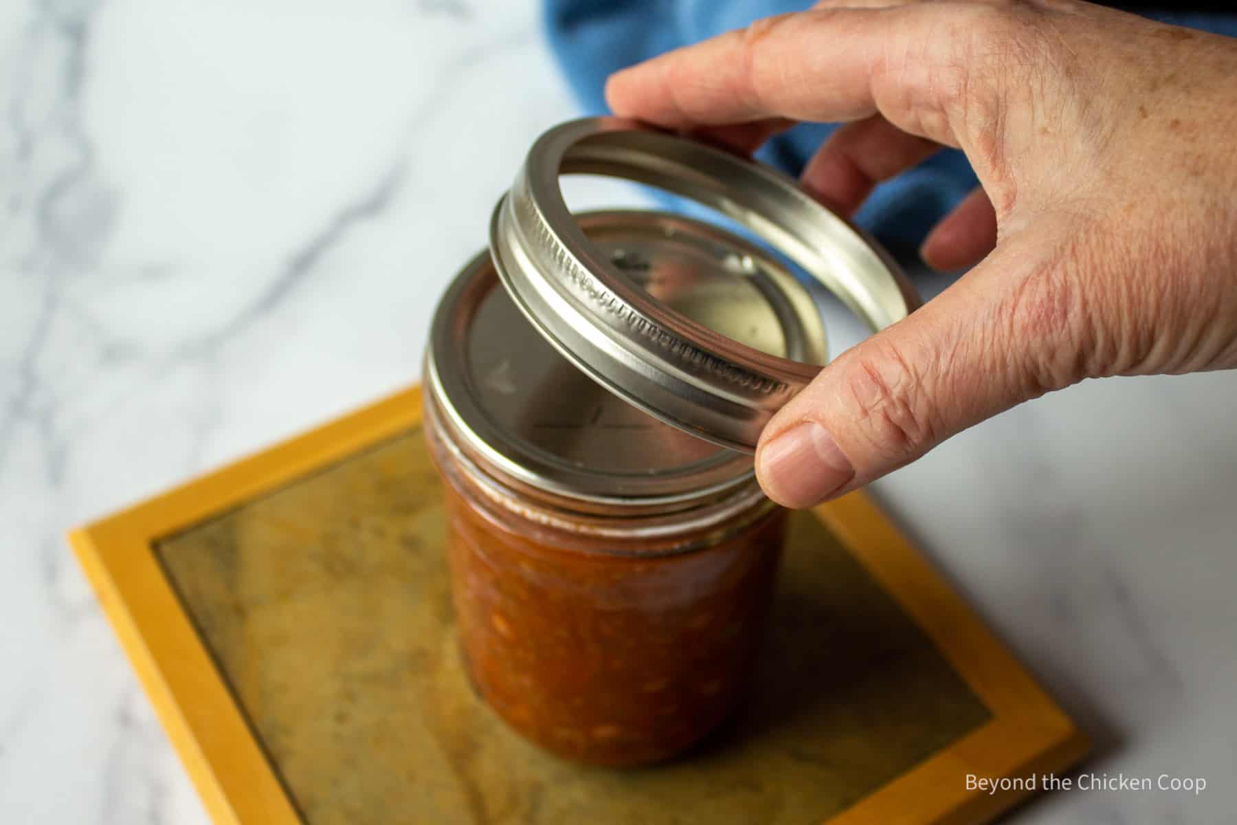 Placing a ring on a canning jar.