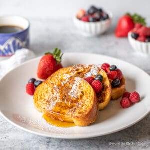 Three pieces of French toast with fresh berries.