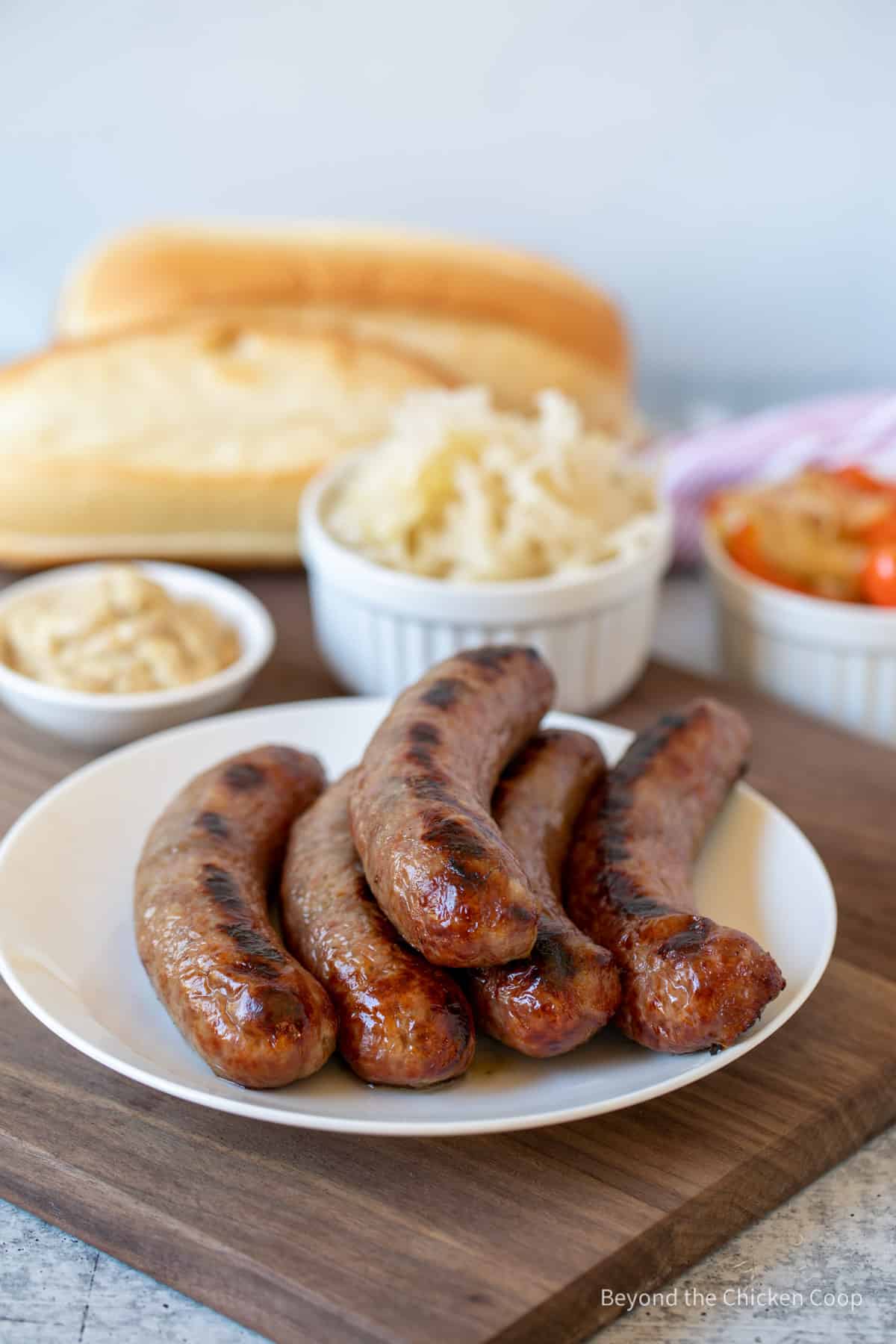 A plate full of cooked bratwurst sausages.