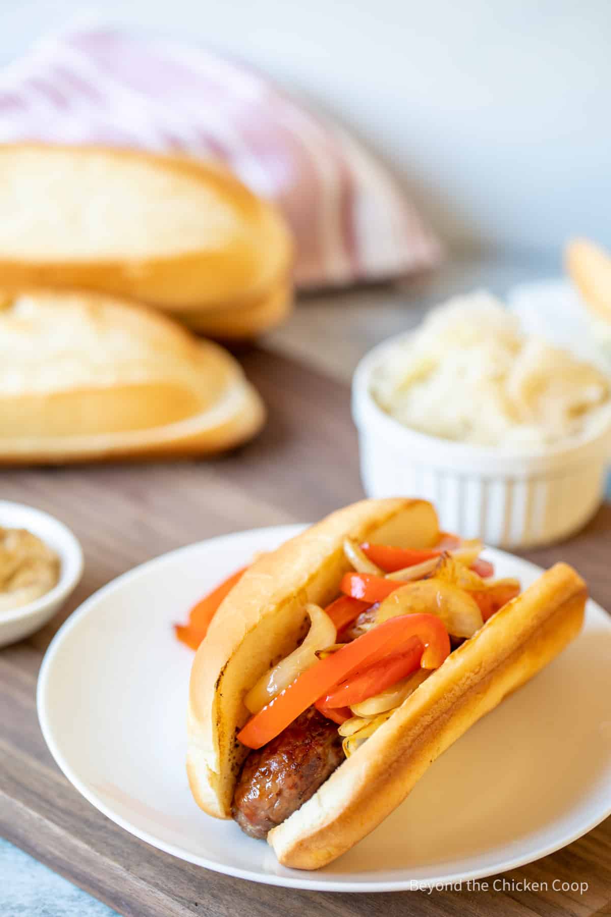 A sausage covered with peppers and onions.