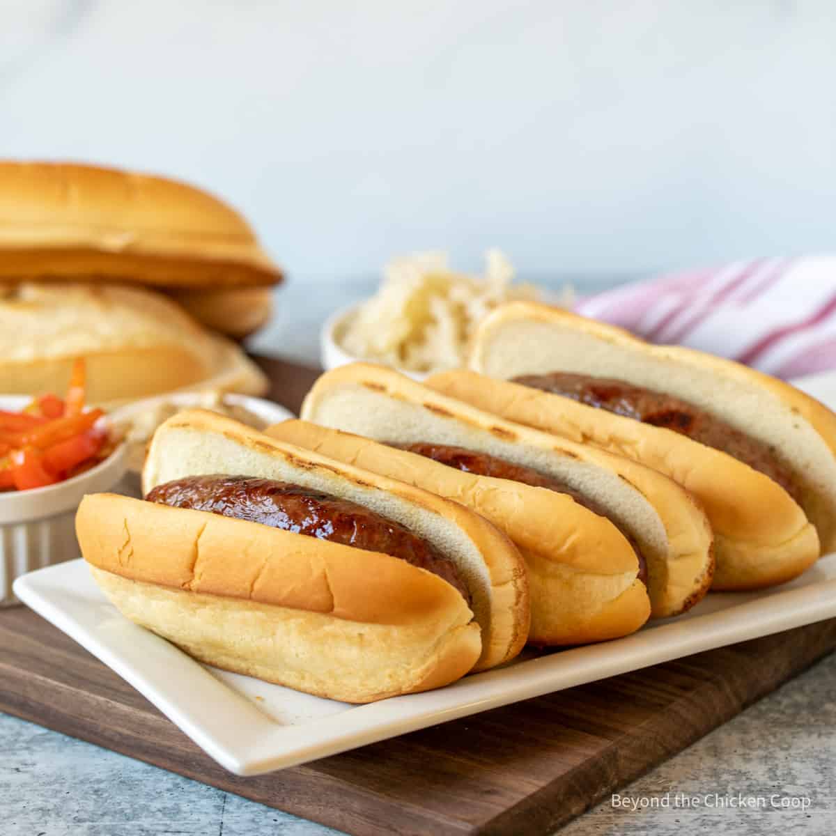 Grilled bratwurst in hoagie rolls.