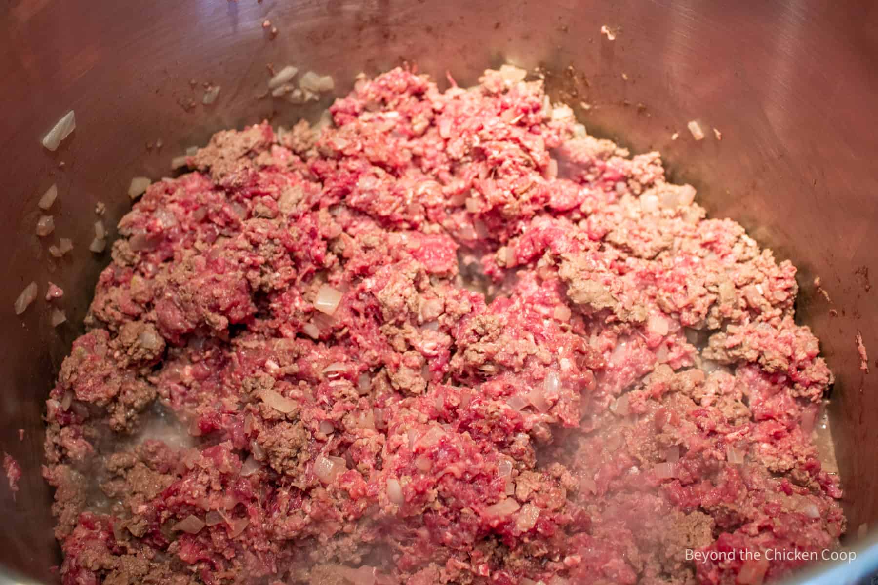 Browning burger in a large pot.