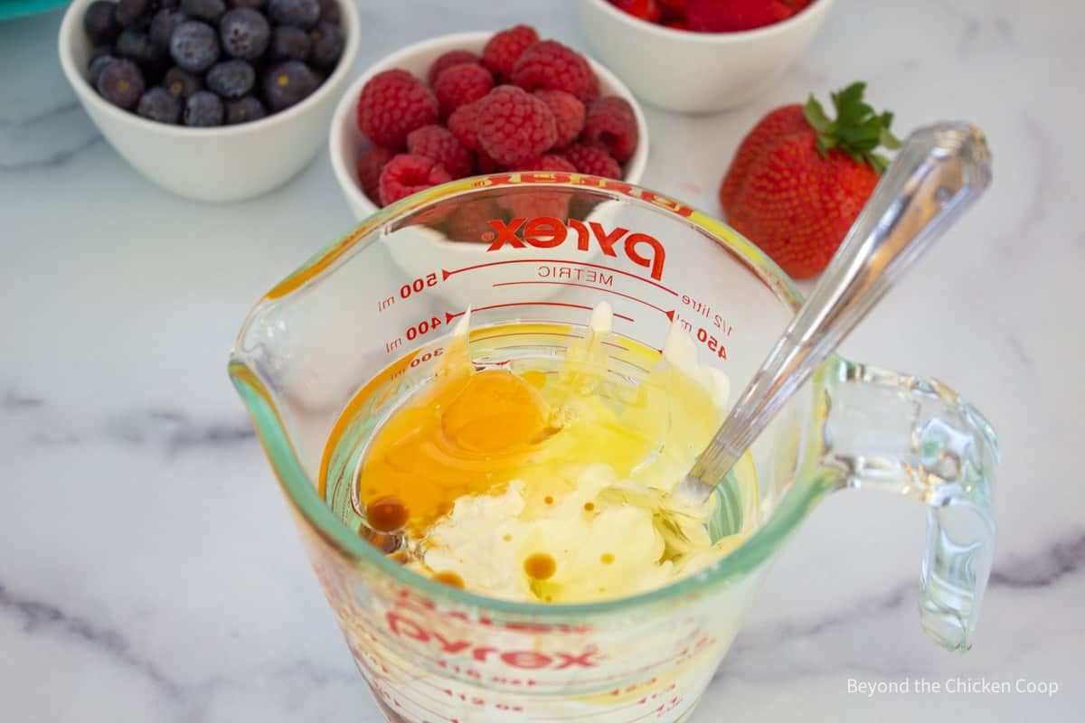 Sour cream, egg and oil in a glass bowl.