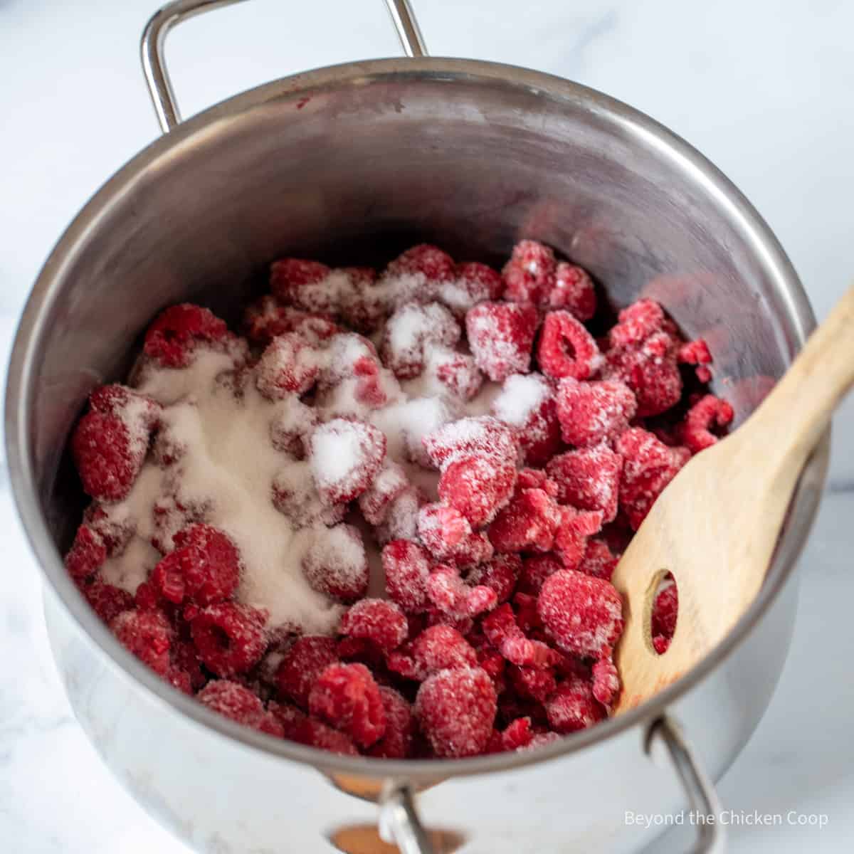 Raspberries and sugar in a pot.