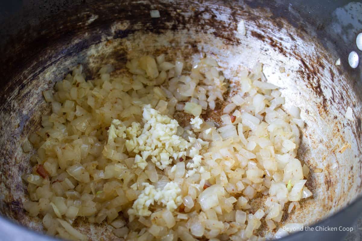 Onions and garlic cooking in a pot. 