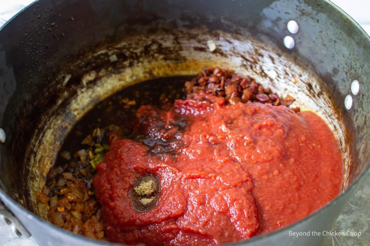 Tomatoes added to a stock pot. 
